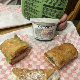 Spicy Italian and Caprese sandwiches, two cannolis and a container of spumoni ice cream.