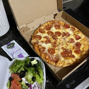 Cheese pizza with pepperoni and side salad