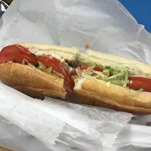 a hot dog with tomatoes and lettuce