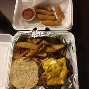 a burger and fries in a styrofoam container