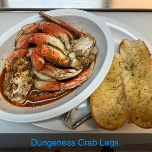 a plate of crab legs with garlic bread