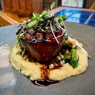 Oak-grilled prime tenderloin with mashed potatoes, grilled carrots, broccolini, barley, and red wine demi