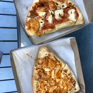 two slices of pizza in boxes