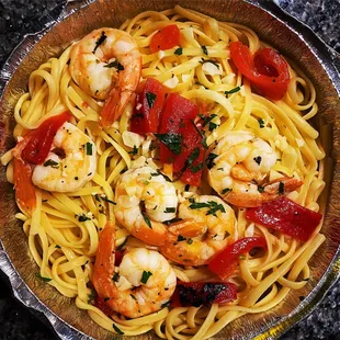 a bowl of pasta with shrimp and tomatoes