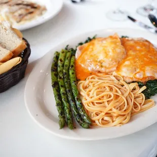 Veal Saltimbocca - veal scallopini topped with prosciutto, sage and melted fontina cheese on a bed of spinach topped with tomato sauce.