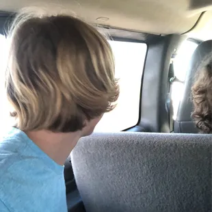 a boy sitting in the back seat of a car