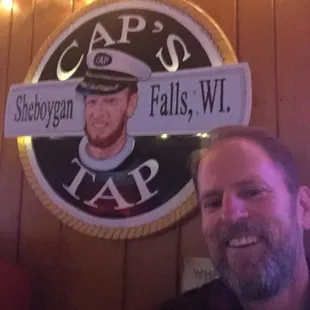 a man sitting in front of a sign