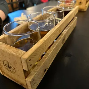 a flight of beer in a wooden crate