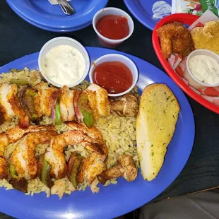 Broiled shrimp kabobs with rice , fried fish, stuffed jalapeño