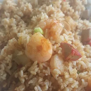 a plate of fried rice with shrimp and vegetables