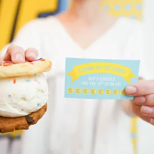 a person holding a card and a cookie