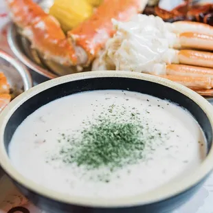 a bowl of crab legs and a bowl of dip