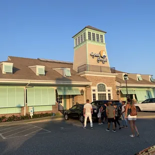 a group of people standing in front of the restaurant