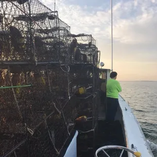 a crab trap being loaded onto a boat