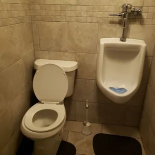 ows a urinal and toilet in a public restroom