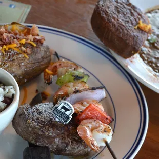 Surf n Turf: A tender made-to-order steak, shrimp skewer, a side of read beans and rice, and a loaded baked potato
