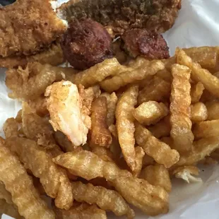 Hard, oily French fries good in old grease and undercooked shrimp batter falling off. overcooked hush puppies. French fries are not edible.