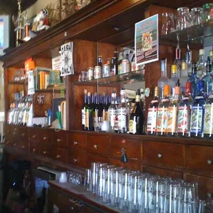 a wooden bar with lots of bottles and glasses