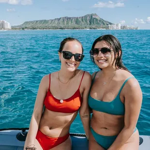 Two friends snorkeling in Waikiki, Honolulu, surrounded by colorful tropical fish,one of the best fun activities and things to do in Hawaii!