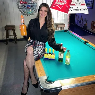 a woman sitting on a pool table