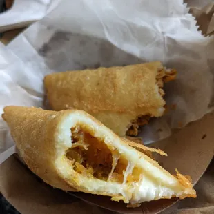 One plantain and cheese and one chicken empanada, half eaten (meaning they were twice as big originally).