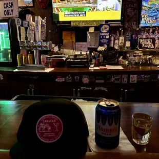a beer and a hat on a bar
