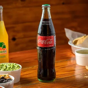 a wooden table with a variety of drinks and condiments