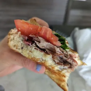 a person holding a sandwich