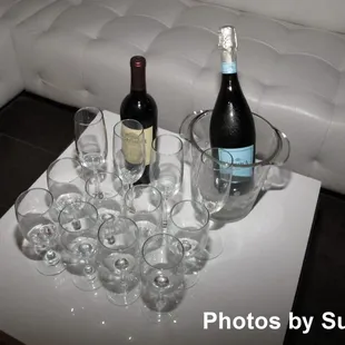 a table with wine glasses and a bottle of wine