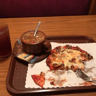 half eaten pizza and a drink