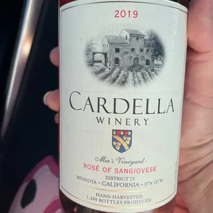 a hand holding a bottle of wine