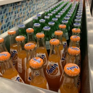 a line of bottles of orange soda