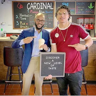two men standing in front of a sign
