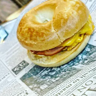 a bagel sandwich on a newspaper