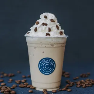 a cup of coffee with whipped cream and coffee beans