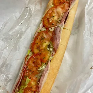 a sub sandwich with tomatoes and lettuce