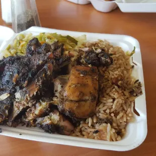 Jerk chicken with oxtail sauce served with rice n peas and cabbage