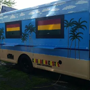 a blue bus with palm trees painted on the side