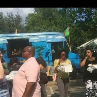 a group of people standing in front of a food truck