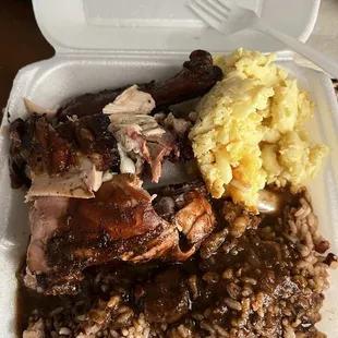 Small ($10) jerk chicken with mac n&apos; cheese and rice and peas w/ oxtail gravy.