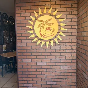 a brick wall with a sun on it