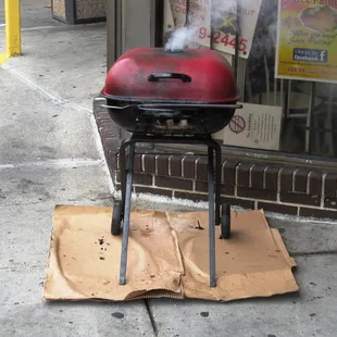 jerk chicken smoking away in front of the restaurant