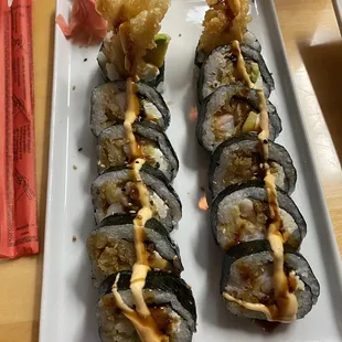 a plate of sushi with shrimp and sauce
