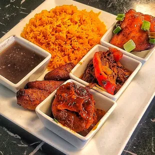 a plate of food with rice, meat, and beans