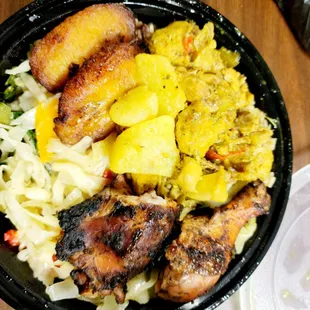 Curry chicken and jerk chicken with rice and peas, cabbage and plantains.