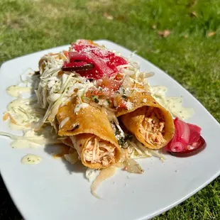 Chicken taquitos, cabbage slaw, secret house dressings and pickled red onions