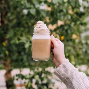 a person holding a jar of coffee