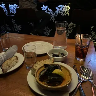 a table with a bowl of soup and bread