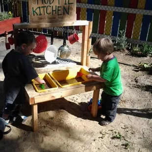 Playing in the mud-pie kitchen.
