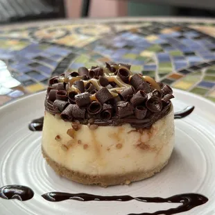 Delicious cheesecake with chocolate and caramel on top.
